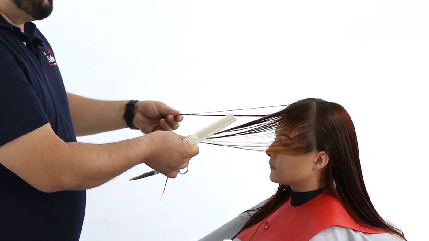 Estilista cortando capas en el cabello de una clienta