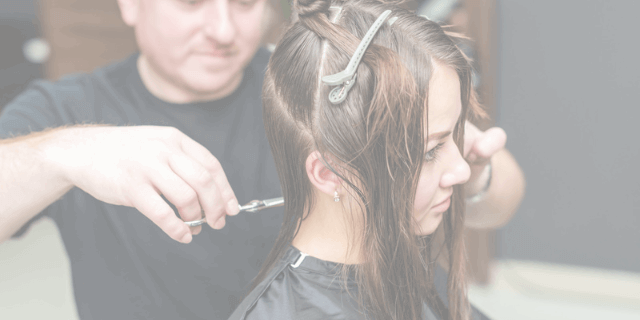 Estilista realizando un corte femenino