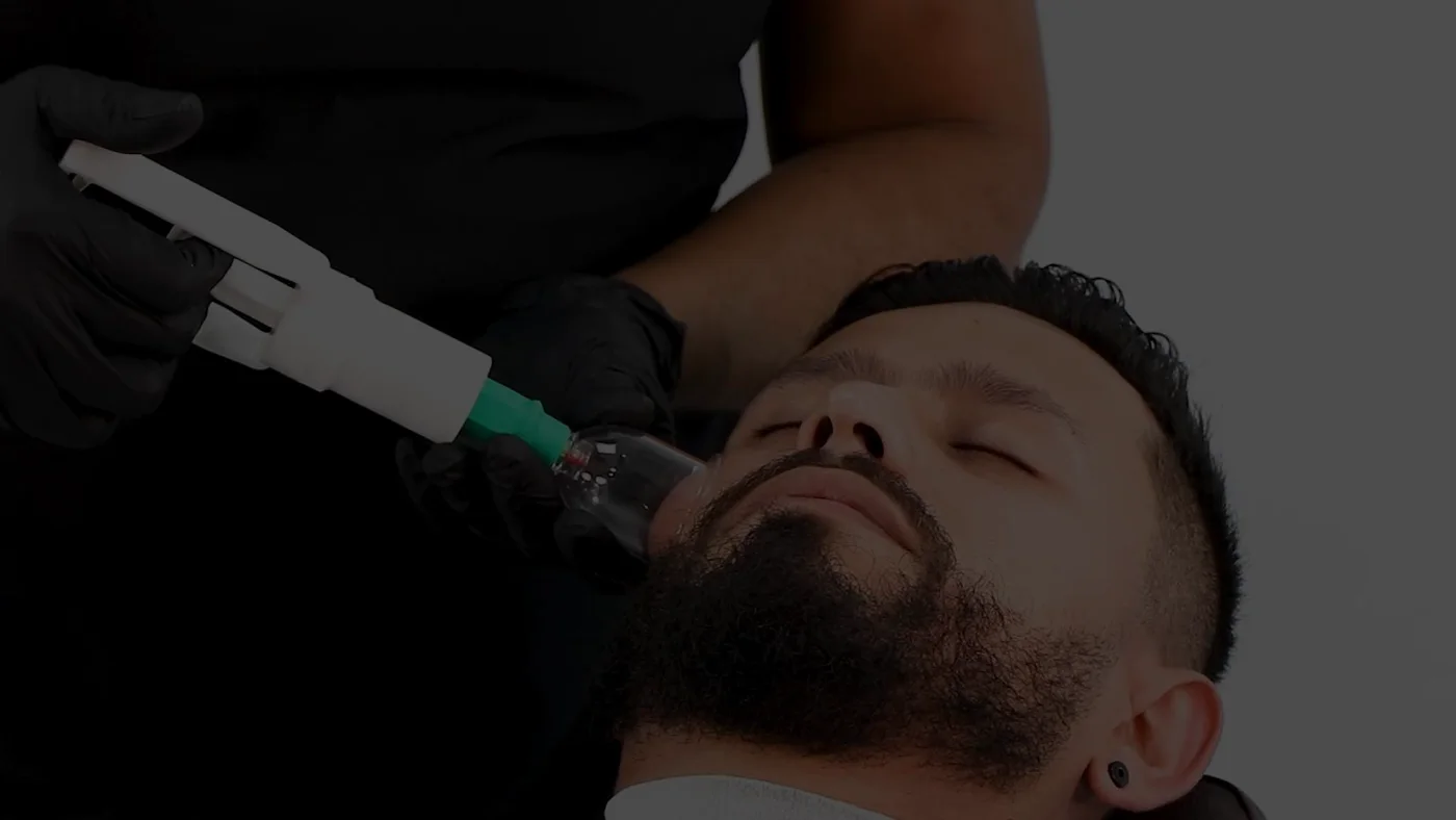 Barbero aplicando alta frecuencia en un tratamiento facial masculino